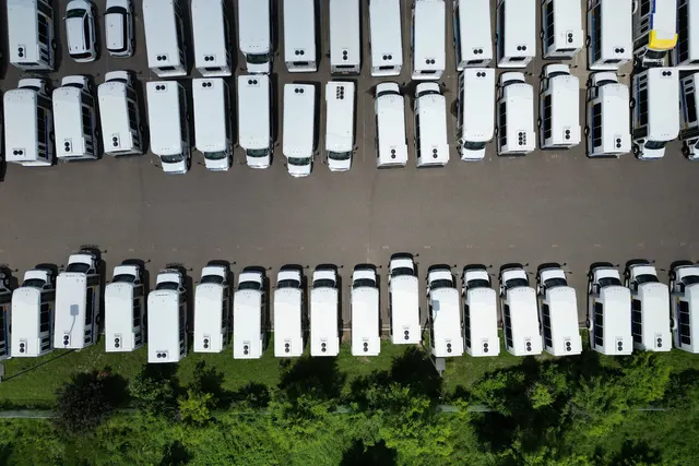 Havadan çekim: sıralı park etmiş beyaz minibüs ve panelvanlar
